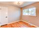 A bedroom featuring hardwood floors, a window, a door and a modern ceiling light fixture at 1170 Kingston St, Aurora, CO 80010
