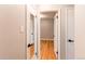 Hallway showing the connection between rooms with hardwood floors and white trim at 1170 Kingston St, Aurora, CO 80010