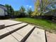 Beautifully landscaped backyard with a lush green lawn, a stone patio, and mature trees at 20558 E Grand Ln, Aurora, CO 80015