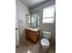 Comfortable bathroom with wooden vanity and toilet, featuring tiled floors and a well lit mirror at 20558 E Grand Ln, Aurora, CO 80015