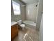 Bright bathroom with tiled shower over tub, window for natural light, and tile flooring at 20558 E Grand Ln, Aurora, CO 80015