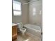 Bright bathroom with tiled shower over tub, window for natural light, and tile flooring at 20558 E Grand Ln, Aurora, CO 80015