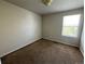 A simple bedroom with neutral carpet and a window allowing natural light at 20558 E Grand Ln, Aurora, CO 80015