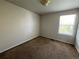A simple bedroom with neutral carpet and a window allowing natural light at 20558 E Grand Ln, Aurora, CO 80015