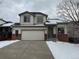 Two-story house with attached garage and snowy front yard at 20558 E Grand Ln, Aurora, CO 80015