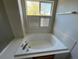 Bathtub with jacuzzi jets and window with shutters at 20558 E Grand Ln, Aurora, CO 80015