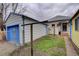 Backyard with a white detached garage, shed and minimal lawn space with foliage at 4514 Bryant St, Denver, CO 80211