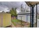 Backyard with a white detached garage, yellow shed and minimal lawn space at 4514 Bryant St, Denver, CO 80211