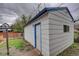 Exterior view of a white detached garage with blue trim, fencing and minimal lawn space at 4514 Bryant St, Denver, CO 80211