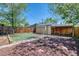 The backyard features privacy fencing, a small patch of grass, and a bed with mulch and pavers around it at 2684 S Logan St, Denver, CO 80210