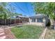 A backyard features an artifical lawn, wood fencing, and a small garden at 2684 S Logan St, Denver, CO 80210