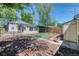 The yard features a small patch of grass, privacy fence, shed and is beautifully landscaped with mulch and pavers at 2684 S Logan St, Denver, CO 80210