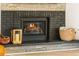 Rustic fireplace with a wooden mantel, brick surround, and cozy accents at 7256 S Broadway, Centennial, CO 80122