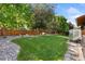 A well-manicured lawn and rock garden with a wooden fence on the property at 139 N Prairie Falcon Pkwy, Brighton, CO 80601