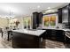 Open-concept kitchen with dark wood cabinets, stainless steel appliances, and an island with a sink at 139 N Prairie Falcon Pkwy, Brighton, CO 80601