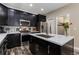 Modern kitchen with stainless steel appliances, dark cabinets, mosaic backsplash, and a center island at 139 N Prairie Falcon Pkwy, Brighton, CO 80601