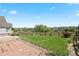 A beautiful backyard space with a brick patio, leading to a lush lawn, a wooden fence, and mature trees at 22935 E River Chase Way, Parker, CO 80138