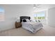 Bright bedroom with large bed, accent wall, fan, and windows with neighborhood views at 22935 E River Chase Way, Parker, CO 80138