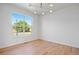 Bright and airy bedroom with hardwood floors, a modern light fixture, and a large window at 22935 E River Chase Way, Parker, CO 80138