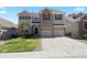 Charming two-story home featuring a well-manicured lawn, three-car garage, and brick and siding exterior at 22935 E River Chase Way, Parker, CO 80138