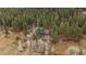A high angle view of the home nestled in a dense forest with meadow below at 7510 Blue Creek Rd, Evergreen, CO 80439