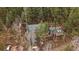 A charming home nestled in a wooded area, with a green roof and a lovely deck at 7510 Blue Creek Rd, Evergreen, CO 80439