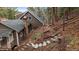 View of the home with stone chimney and wood fence bordering the yard at 7510 Blue Creek Rd, Evergreen, CO 80439