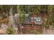 Charming cabin-style home with a green roof, perched on stilts amidst a lush forest at 7510 Blue Creek Rd, Evergreen, CO 80439