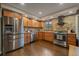 Bright kitchen featuring stainless steel appliances, wood cabinets, stone backsplash, and wood flooring at 7510 Blue Creek Rd, Evergreen, CO 80439