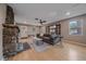 Bright living room featuring a stone fireplace, hardwood floors, and comfortable seating at 7510 Blue Creek Rd, Evergreen, CO 80439