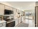 Modern kitchen with stainless steel appliances, light colored cabinets, and a sliding door at 7452 W Cedar Cir, Lakewood, CO 80226