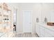 Bright bathroom with a shelf and large mirror over the double sink at 6764 Osage St, Denver, CO 80221
