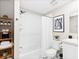 A bright bathroom features white tile, a shower/tub combo, and a white vanity sink at 6764 Osage St, Denver, CO 80221