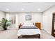 Bright bedroom has neutral walls, plush carpet, a modern bed frame and a dresser at 6764 Osage St, Denver, CO 80221