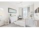 Brightly lit Bedroom with white furniture, plush rug and large window at 6764 Osage St, Denver, CO 80221