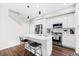 This kitchen has quartz countertops, stainless appliances, seating at the kitchen island and dark hardwood floors at 6764 Osage St, Denver, CO 80221