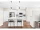 Sleek, modern kitchen with white cabinets, stainless steel appliances, and island with breakfast bar at 6764 Osage St, Denver, CO 80221