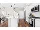 Modern kitchen featuring white cabinetry, stainless steel appliances, and hardwood floors with an open floorplan at 6764 Osage St, Denver, CO 80221