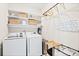 Functional laundry room with washer, dryer, and shelving for storage at 6764 Osage St, Denver, CO 80221