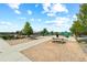 View of a park with picnic tables, trash cans, and gated dog park area under a bright sky at 6764 Osage St, Denver, CO 80221