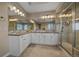 Luxurious bathroom featuring dual sinks, a walk-in shower with glass door, and large mirror at 14589 Hagus Pl, Parker, CO 80134