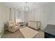 Charming Bedroom showcasing a white crib, comfortable armchair, stylish light fixture and decorative rug at 14589 Hagus Pl, Parker, CO 80134