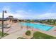 Community pool and clubhouse with lounge chairs, tables and umbrellas, and lush landscaping at 14589 Hagus Pl, Parker, CO 80134