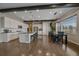 Modern kitchen with white cabinets, a large center island, stainless appliances and a dining area at 14589 Hagus Pl, Parker, CO 80134