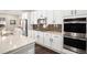 Modern kitchen featuring white cabinets, granite countertops, stainless steel appliances, and a stylish backsplash at 16195 Red Bud Loop, Parker, CO 80134