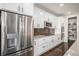 Bright kitchen boasts stainless steel refrigerator, white cabinets, granite counters, and an adjacent pantry at 16195 Red Bud Loop, Parker, CO 80134