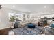 Spacious living room with large sectional sofa, accent rug, and views of the kitchen and dining area at 16195 Red Bud Loop, Parker, CO 80134