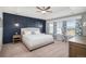 Spacious main bedroom featuring a navy accent wall, tray ceiling and bright windows at 16195 Red Bud Loop, Parker, CO 80134