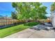 Large backyard featuring a lush lawn, concrete patio, wooden fence, and mature trees at 7755 E Quincy Ave # 104A1, Denver, CO 80237