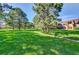 Expansive, grassy community lawn with mature trees and well-maintained landscaping at 7755 E Quincy Ave # 104A1, Denver, CO 80237